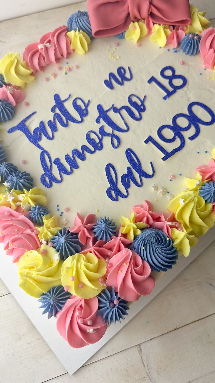 a birthday cake with blue, yellow and pink frosting