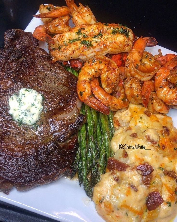 steak, shrimp, and asparagus on a white plate