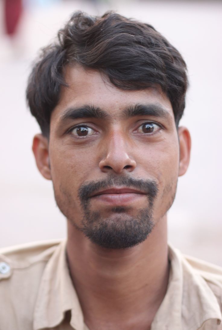 a close up of a person wearing a shirt and looking at the camera with a serious look on his face