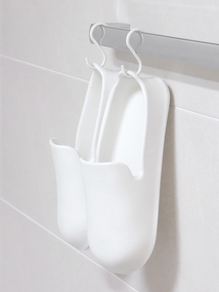 three white utensils hanging on the wall