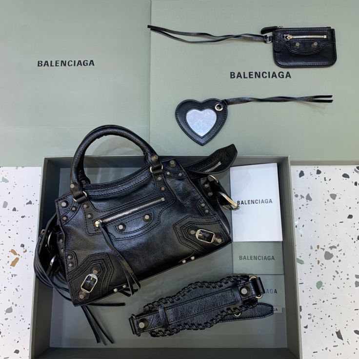 Description Balen Neo Cagole XS Handbag In Black, For Women,  Bags 10.2in/26cm 700940210B01000 Rep 1:1 Size:  25.9x 17.9 x 11.4 cm /10.2 x 7 x 4.5 inches (Lenght x Height x Width) Trapezoidal shape Two hand Adjustable and removable strap Zipped closure with knotted puller Front zipped pocket with knotted puller 1 inner zipped pocket 1 removable zipped pouch 1 removable heart mirror Tone-on-tone Balen logo embossed on mirror Includes dust bag. This product is of the best quality. Black Balenciaga, Motorcycle Bag, Lv Purse, Lv Shoes, Balenciaga Logo, Lv Belt, Lv Wallet, Lv Handbags, Balenciaga Bag