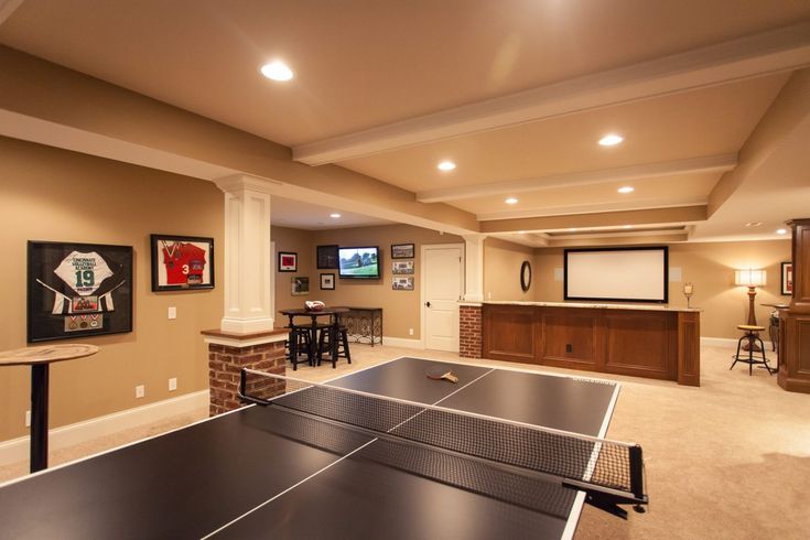 a game room with ping pong tables and bar