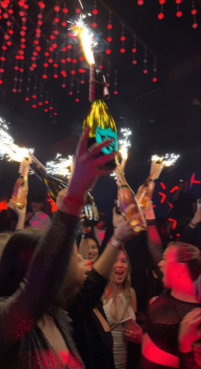 a group of people holding sparklers up in the air