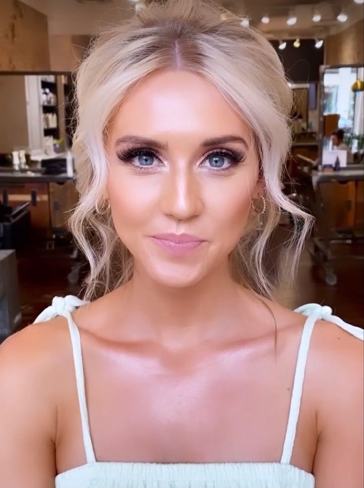 a woman with blonde hair and blue eyes is looking at the camera while wearing a white dress