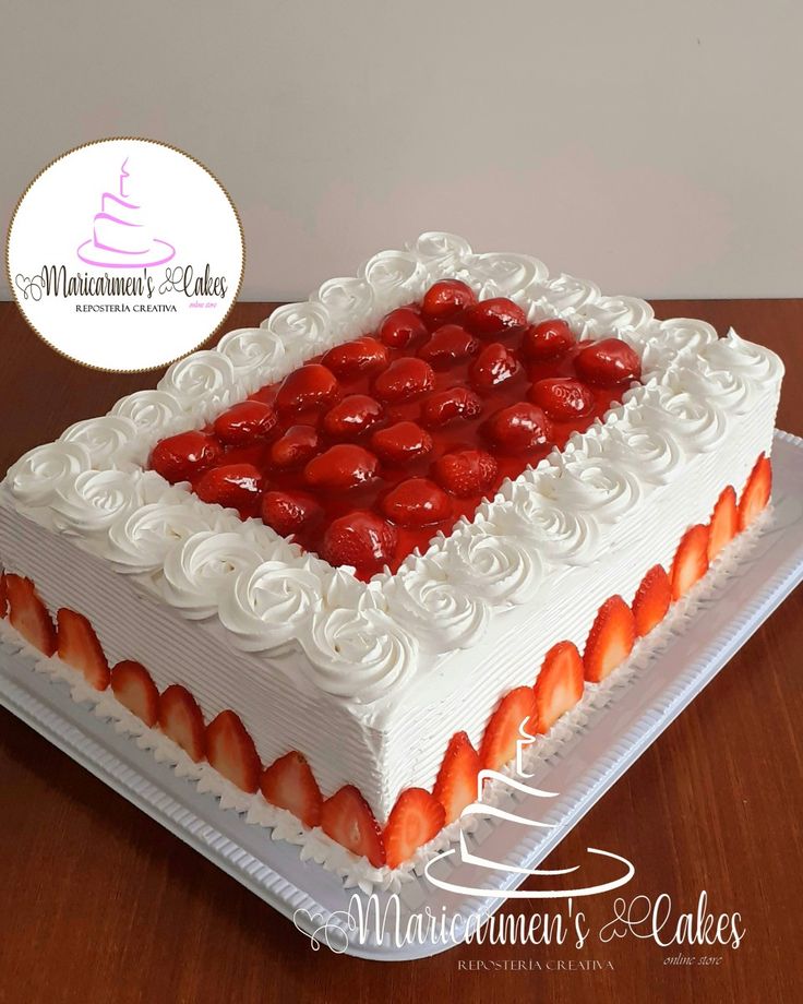 a cake with white frosting and strawberries on top is sitting on a table