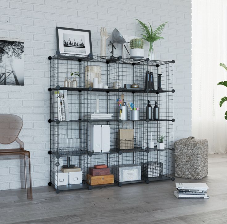 a living room with a white brick wall and shelving unit