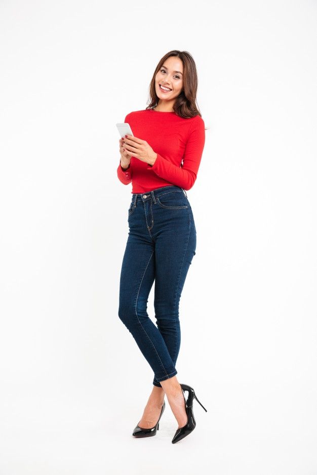 a woman standing with her arms crossed and looking at the camera while wearing high heels