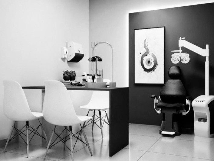 a room with chairs, a table and a dentist's chair next to the counter