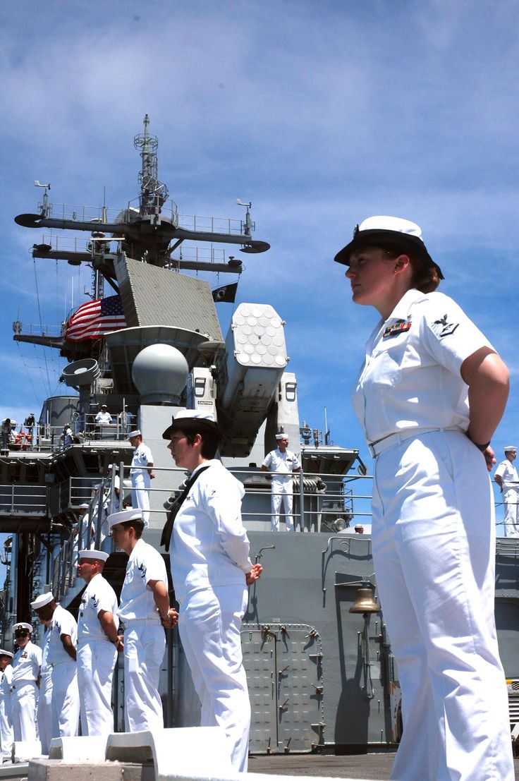 sailors in white uniforms standing on the deck of a ship