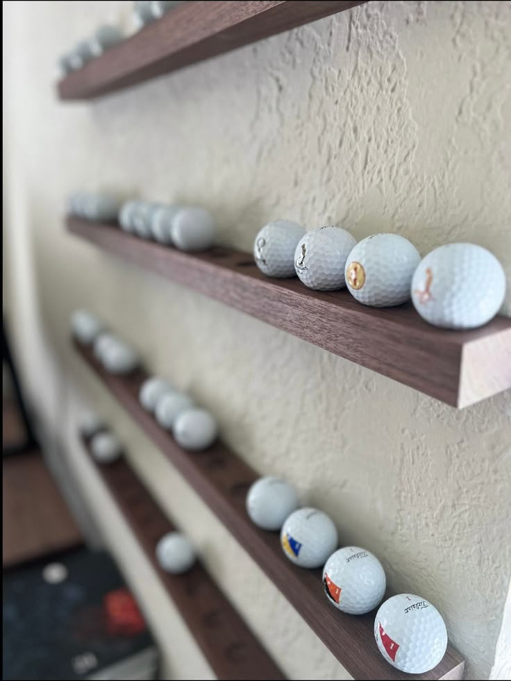 there are many golf balls on the shelves and one is in front of the wall