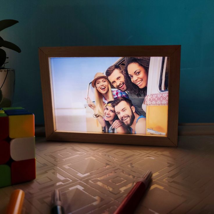 a photo frame sitting on top of a table next to a pencil and eraser