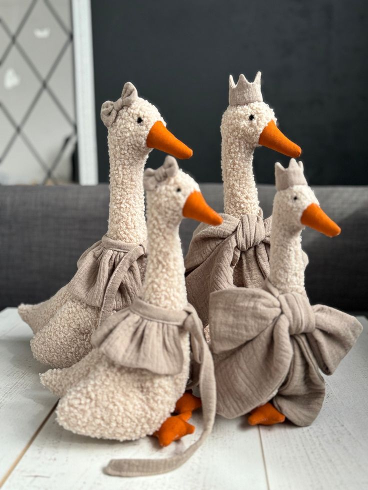 three stuffed ducks sitting on top of a table