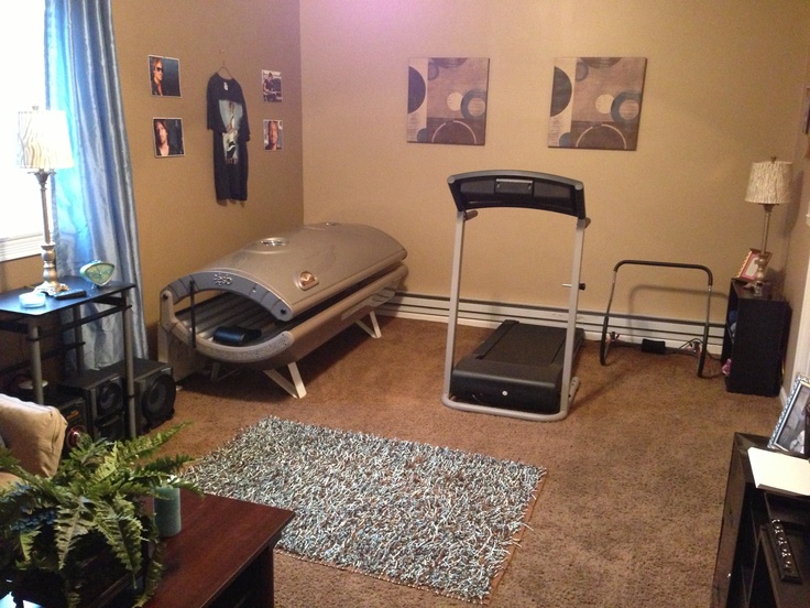 a living room filled with furniture and a treadmill in the middle of the floor