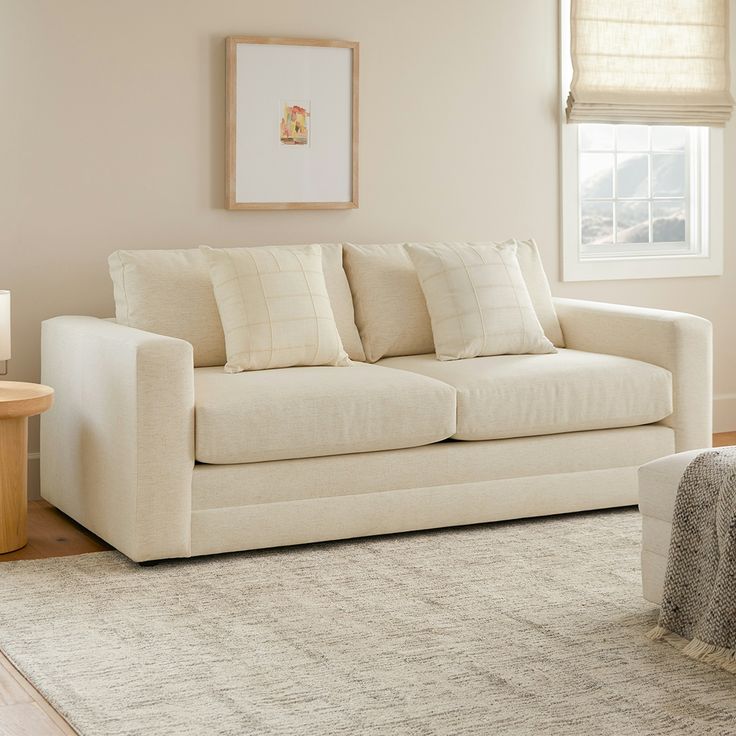 a living room with a white couch and rug