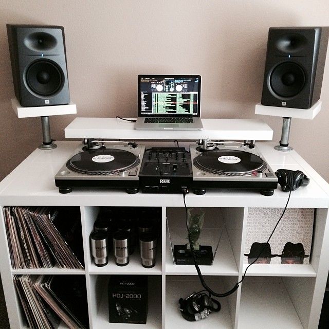 a dj's turntable with two speakers and a laptop on the top shelf