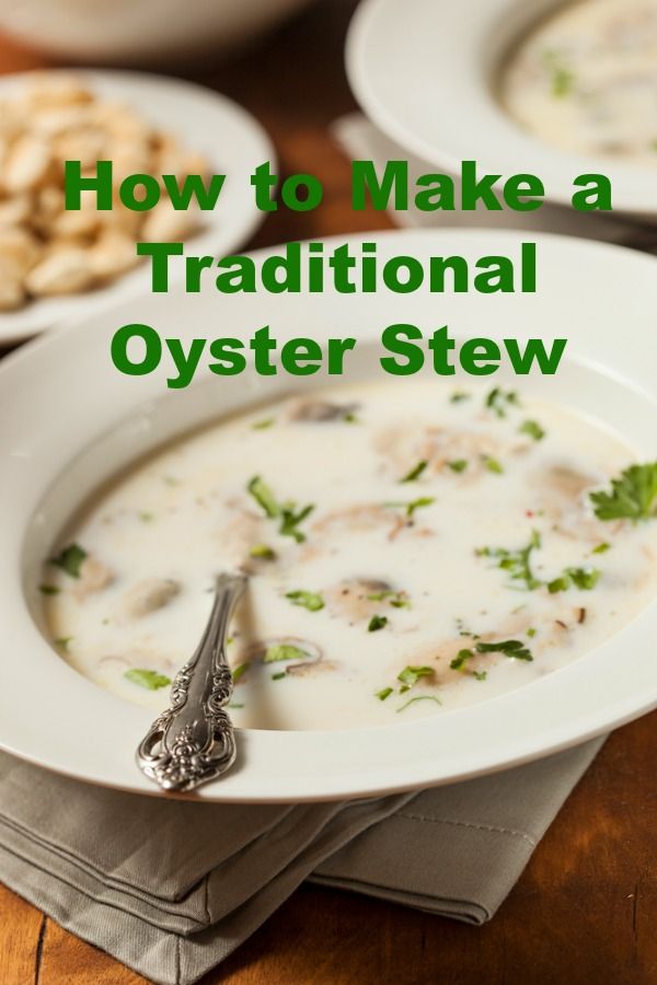 a white bowl filled with soup on top of a wooden table next to crackers