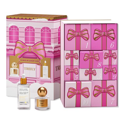 a pink box with gold bow and two bottles in front of it, next to the packaging