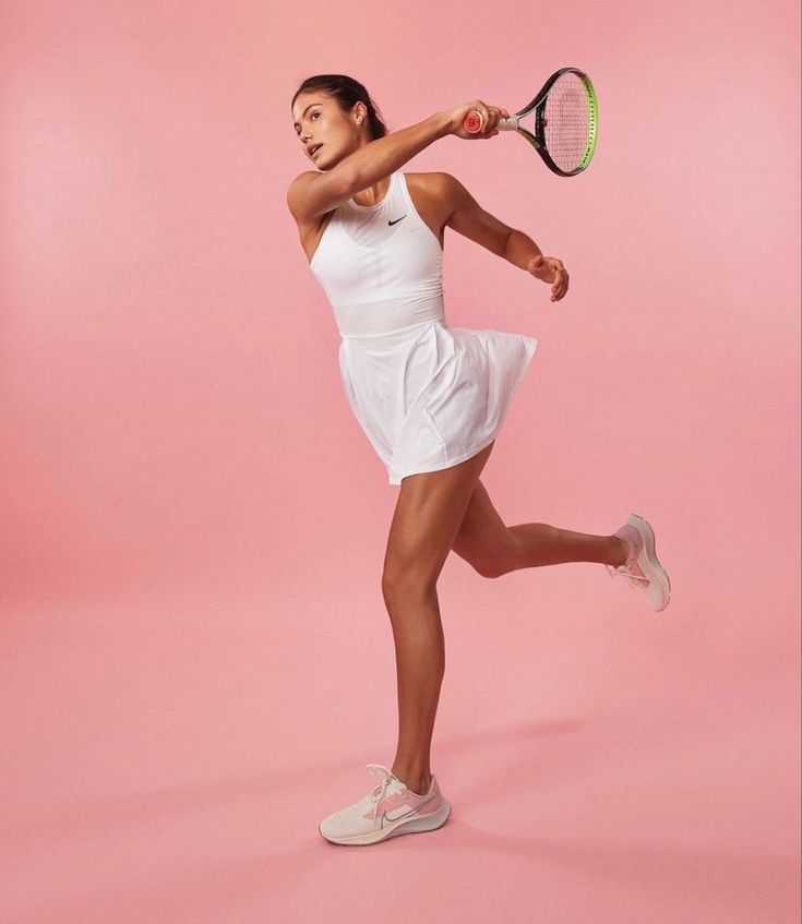 a female tennis player in a white dress