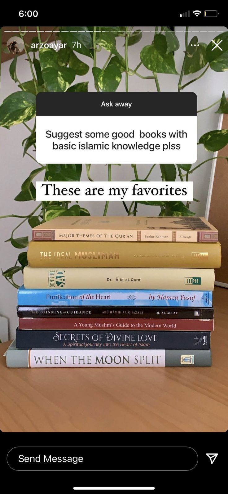 a stack of books sitting on top of a wooden table next to a plant in a vase