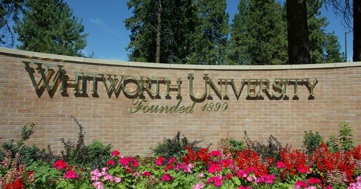 the sign for whitworth university surrounded by flowers