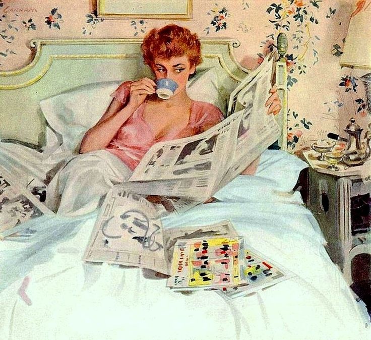 a woman laying in bed reading a newspaper and drinking from a cup with her hand