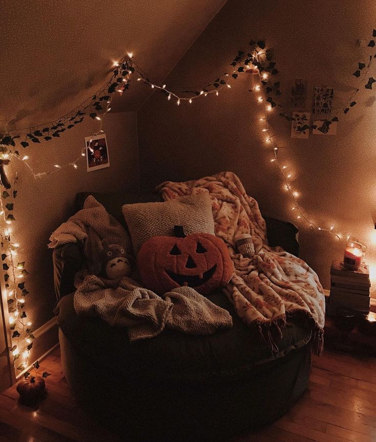 a room with lights and decorations on the walls, including a bed covered in pumpkins