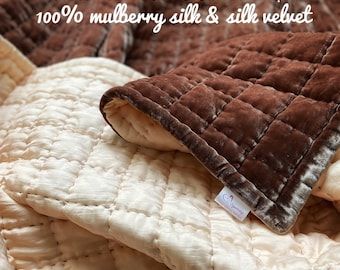 a pile of blankets sitting on top of each other with the words 100 % mulberry still & all velvet