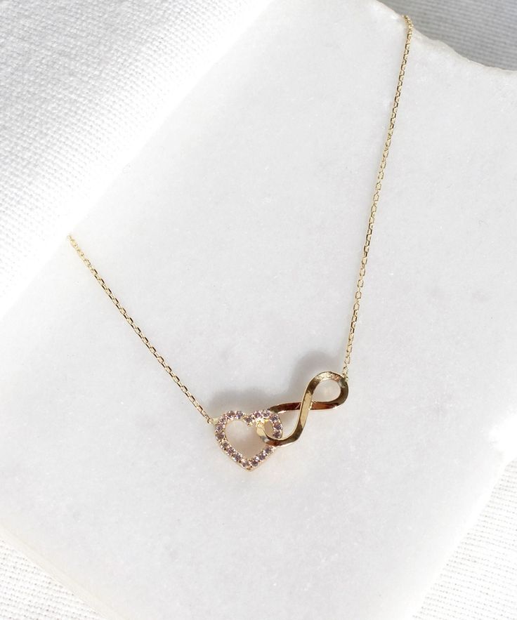 14K Gold Heart and Infinity Symbol Necklace A symbol of infinite love, this elegant necklace showcases the symbols of love and eternity entwined with each other. The heart motif perfectly complements the infinity symbol for a truly romantic look. This unique necklace is perfect for everyday wear as it is made of solid gold and won't tarnish. It is a wonderful gift for a special person. Features: * This necklace is made of patented 14K solid gold. * Length: 42 cm Packaging: You will get your jewe Elegant Heart Necklace With Adjustable Chain For Anniversary, Diamond Infinity Necklace For Gift, Infinity Jewelry With Diamond Accents For Gift, Rose Gold Infinity Necklace For Anniversary, Infinity Necklace With Diamond Accents For Gifts, Sterling Silver Infinity Necklace Fine Jewelry, Cubic Zirconia Infinity Necklace For Anniversary, Infinity Necklace For Anniversary Gift, Infinity Shaped Jewelry With Diamond Accents For Mother's Day