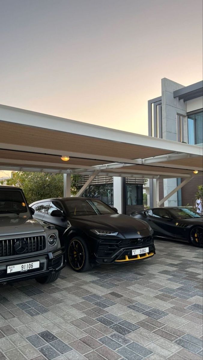 three cars parked in front of a building with people standing around them and one car is black