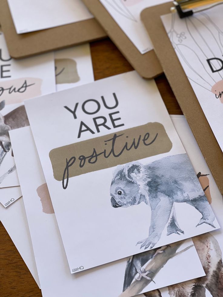 there are many postcards on the table with animals and words written on them that say you are positive