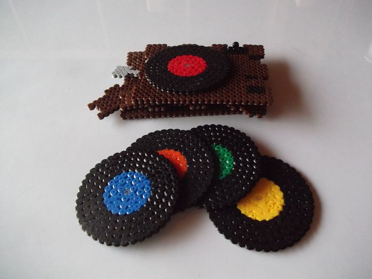 there are four pieces of beaded crafting that look like old record players on the table