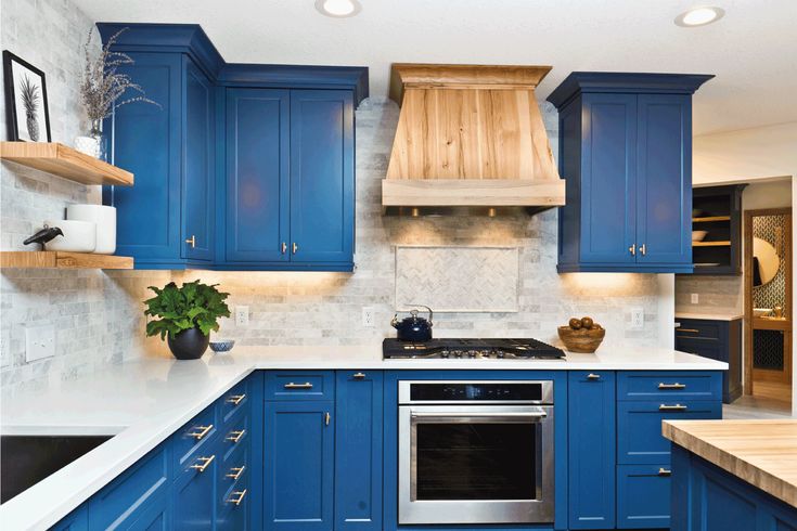 a kitchen with blue cabinets and an arrow pointing to the oven in the middle of the room