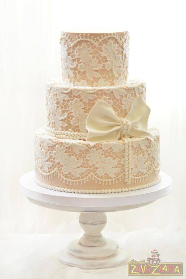 a three tiered wedding cake with a bow on top