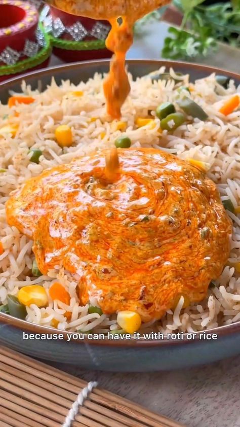 a plate with rice and vegetables being sprinkled with orange sauce on the side