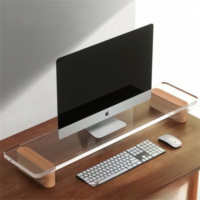 a computer monitor sitting on top of a wooden desk next to a keyboard and mouse