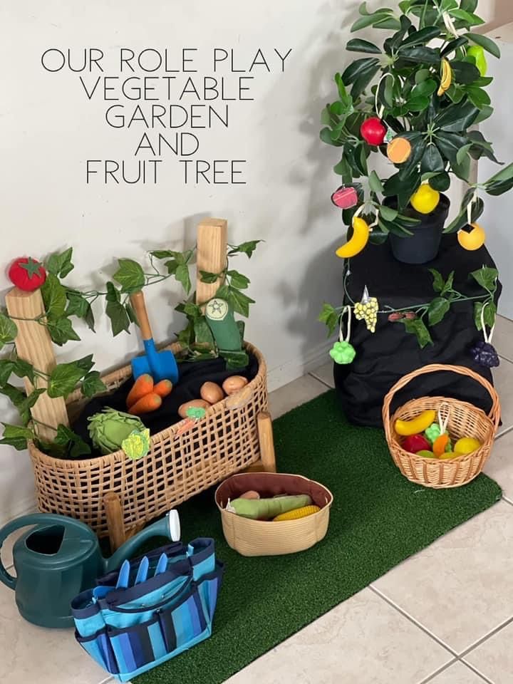 there are many fruits and vegetables in baskets on the floor next to a sign that says our role play vegetable garden and fruit tree