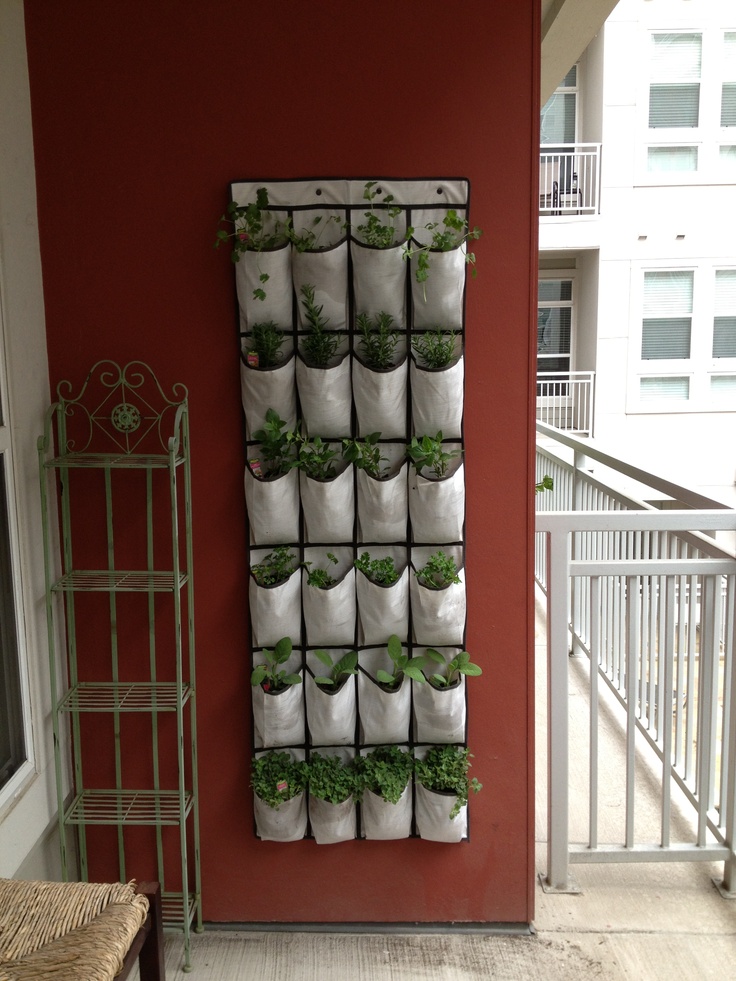 a wall mounted planter filled with plants next to a stair case on the side of a building