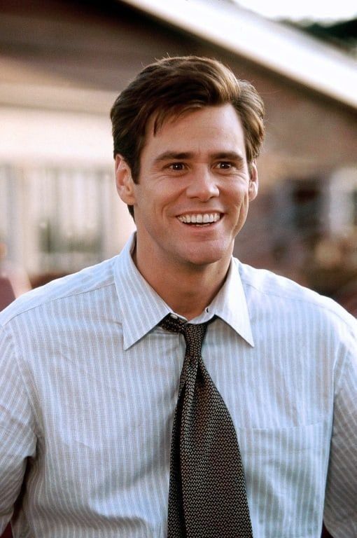 a man wearing a shirt and tie smiling