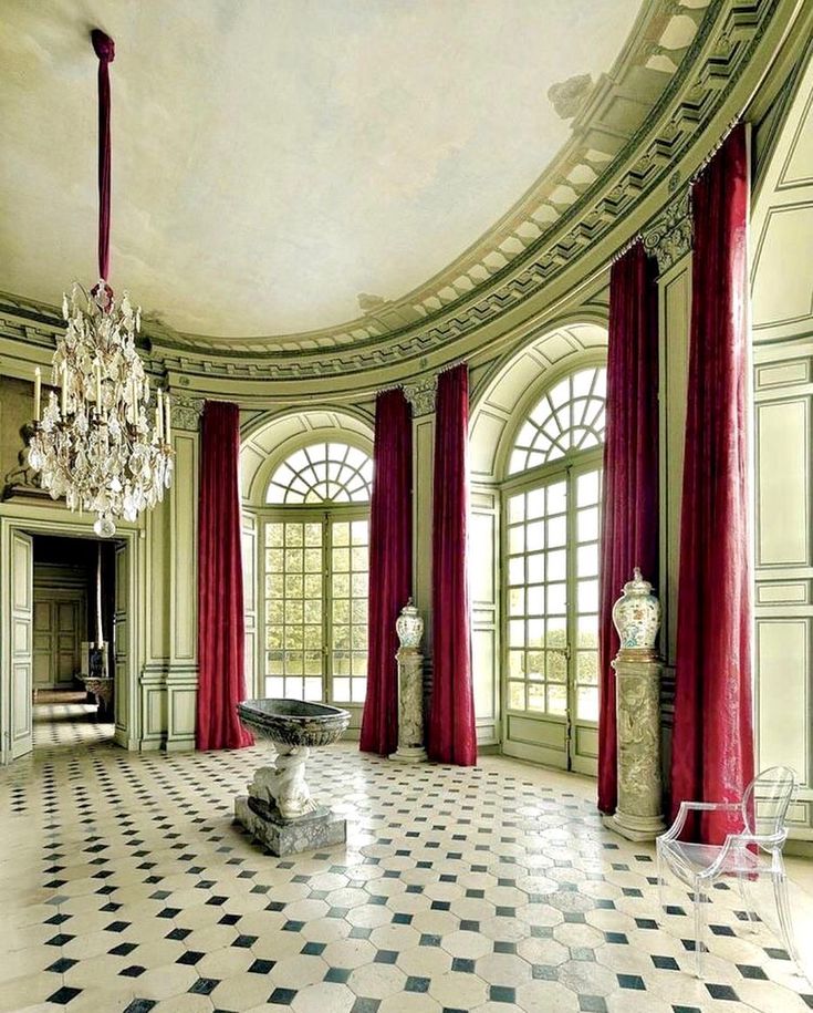 an ornate room with chandelier, marble table and checkered tile flooring