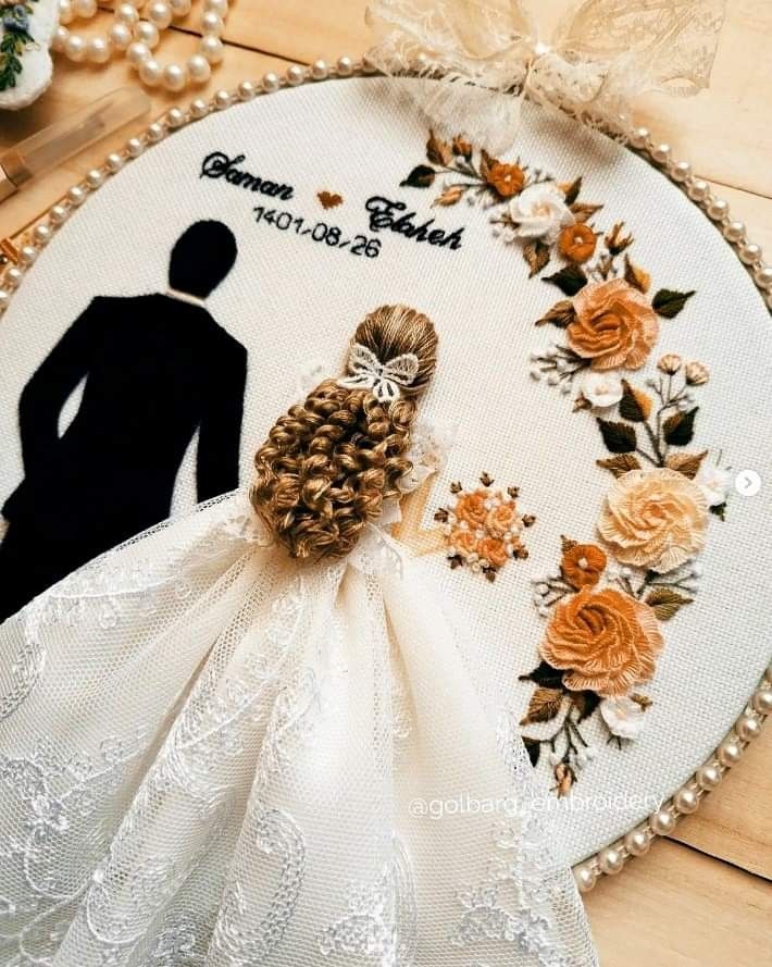 the bride and groom are depicted in this embroidery pattern on a white hoop with flowers