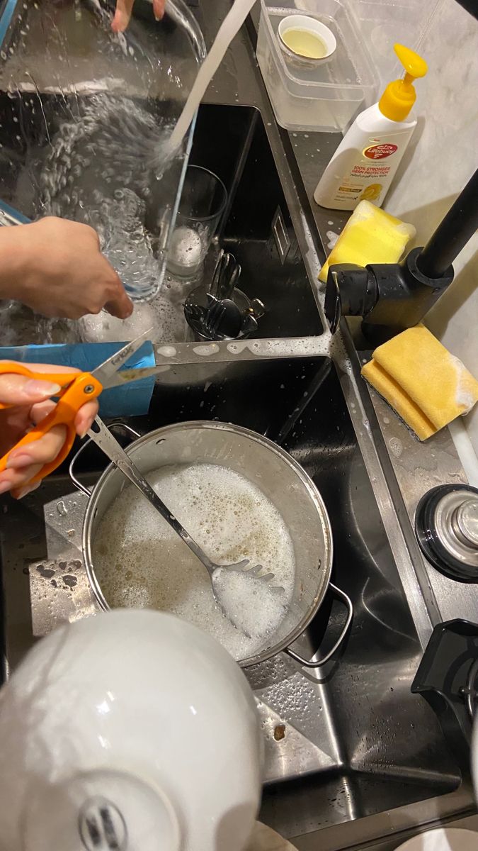 a person is washing dishes in a sink