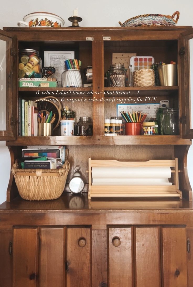 a wooden hutch filled with books and other items