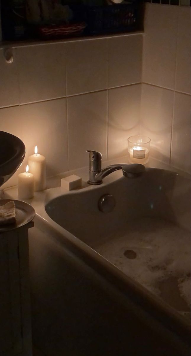 a bathtub with candles and soap in it