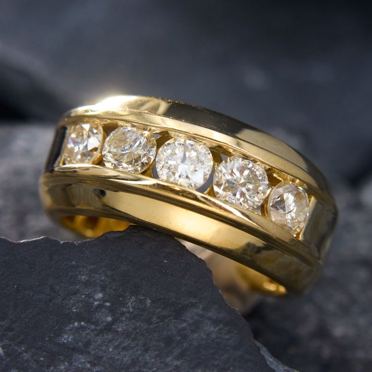 a yellow gold wedding band with five diamonds