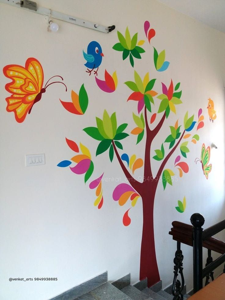 colorful tree with birds and butterflies painted on the wall