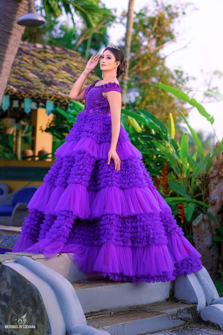 a woman in a purple dress standing on some steps