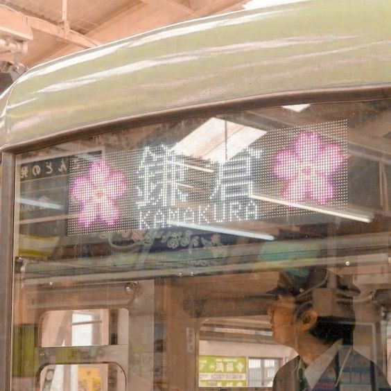 a man standing on the side of a bus looking at it's display screen