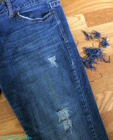 an old pair of blue jeans with holes on them