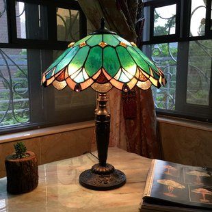 a lamp sitting on top of a table next to a window