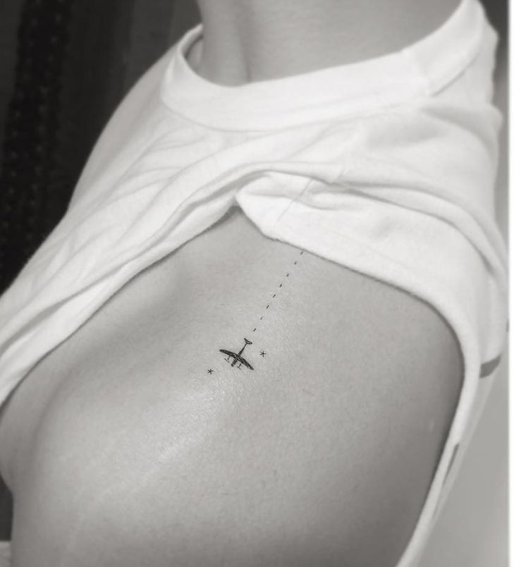 a woman with a small airplane tattoo on her lower back side ribcacture